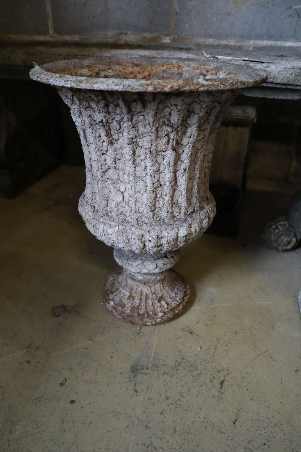 A pair of Victorian cast iron campana garden urns (one lacking plinth foot and rim), taller 49cm